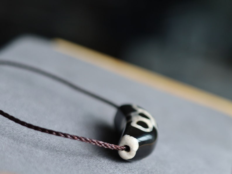Unique shape DZI. The "Lightning" pattern in relation to Dzi beads refers to a specific type of Dzi bead that has a unique appearance resembling a lightning bolt or zigzag pattern.