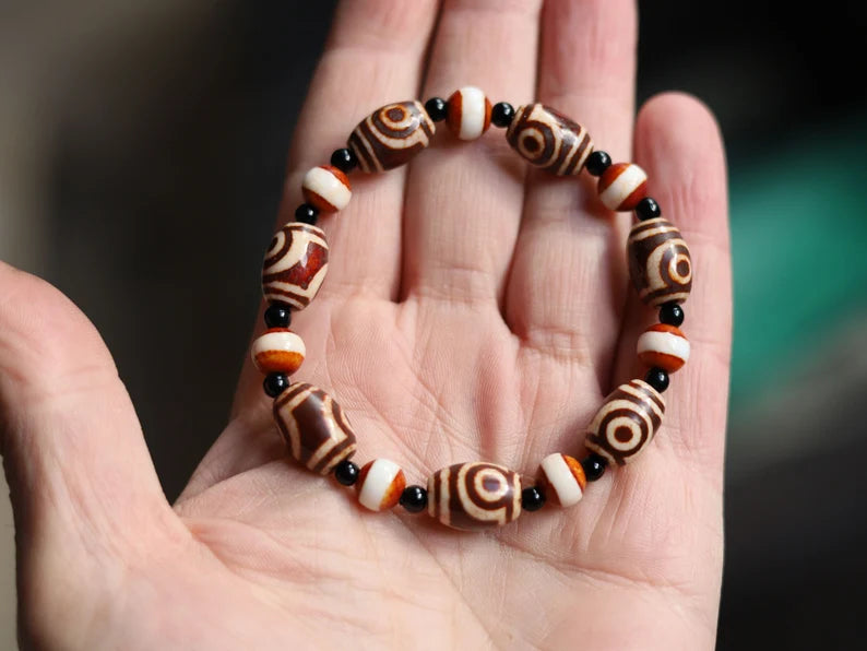 Tibetan Collections Two Eyes Dzi Bead.  These Dzi beads are known as Love Stones. Designed and handmade and stringed by strong elastic cords