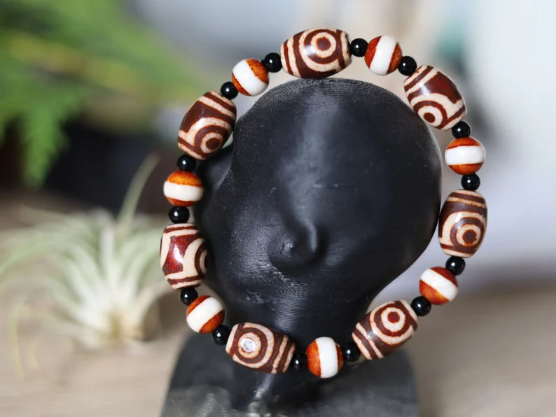 Tibetan Collections Two Eyes Dzi Bead.  These Dzi beads are known as Love Stones. Designed and handmade and stringed by strong elastic cords