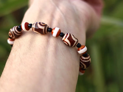 Tibetan Collections Two Eyes Dzi Bead.  These Dzi beads are known as Love Stones. Designed and handmade and stringed by strong elastic cords