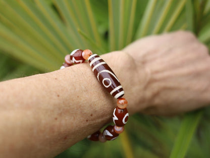 Two-eye dZi bead with Universe Dzi Bead | Sun/Moon. The sun, moon, and star painted on this Dzi bead represent this universal life energy.