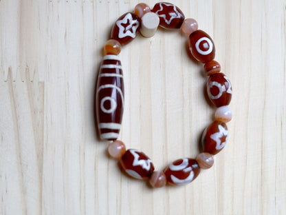Two-eye dZi bead with Universe Dzi Bead | Sun/Moon. The sun, moon, and star painted on this Dzi bead represent this universal life energy.