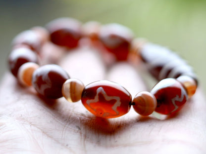 Two-eye dZi bead with Universe Dzi Bead | Sun/Moon. The sun, moon, and star painted on this Dzi bead represent this universal life energy.