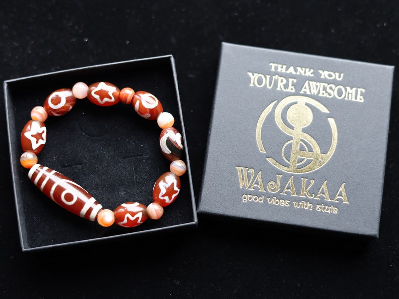 Two-eye dZi bead with Universe Dzi Bead | Sun/Moon. The sun, moon, and star painted on this Dzi bead represent this universal life energy.