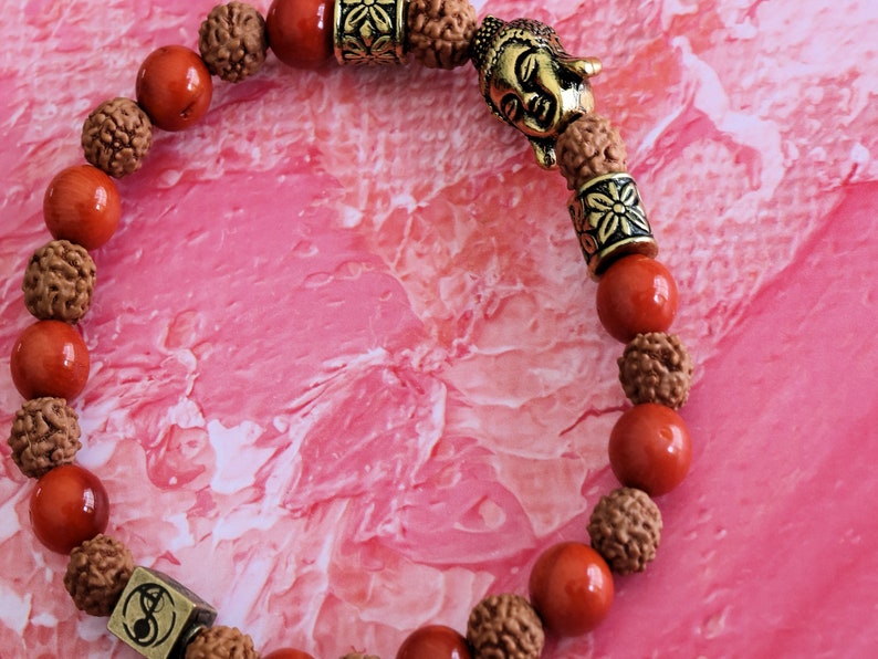 Godlike Red Coral / Rudraksha bracelet with Antique Style Buddha head and Wajakaa © Logo bead.  ‘one who is awake’