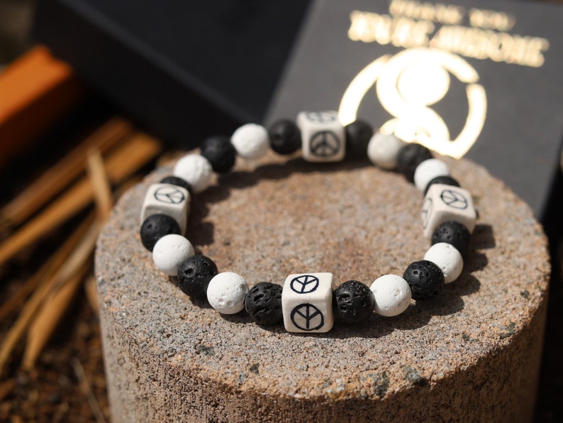 Peaceful black and white Lava stones bracelet combined with Ceramic Cube Peace Sign. Designed for the British nuclear disarmament movement