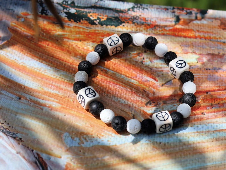 Peaceful black and white Lava stones bracelet combined with Ceramic Cube Peace Sign. Designed for the British nuclear disarmament movement