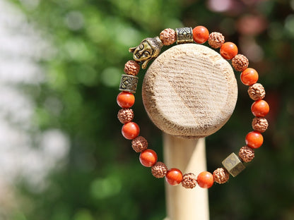 Godlike Red Coral / Rudraksha bracelet with Antique Style Buddha head and Wajakaa © Logo bead.  ‘one who is awake’