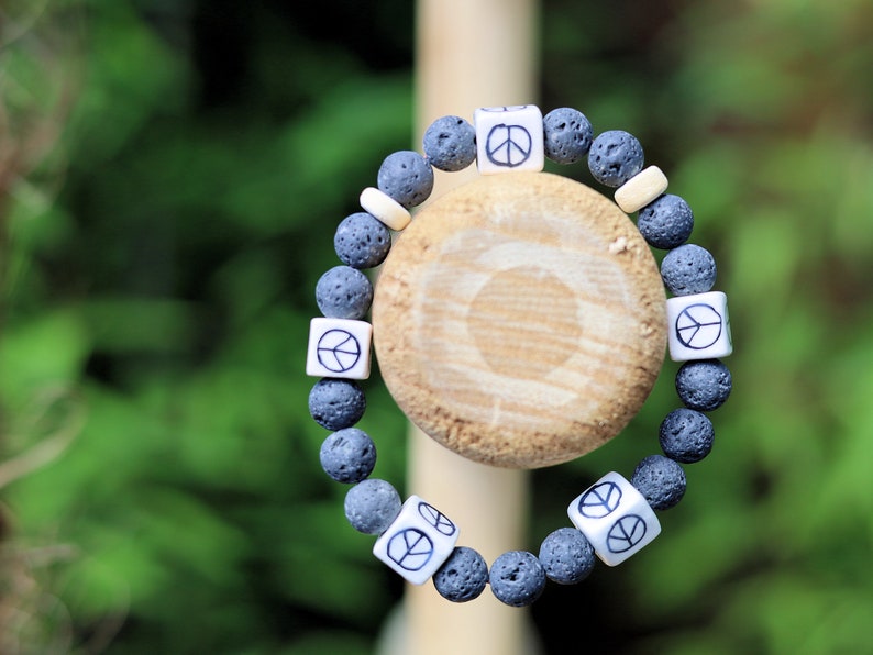 Peaceful grey Lava stones bracelet combined with Ceramic Cube Peace Sign Design.Symbol designed for the British nuclear disarmament movement