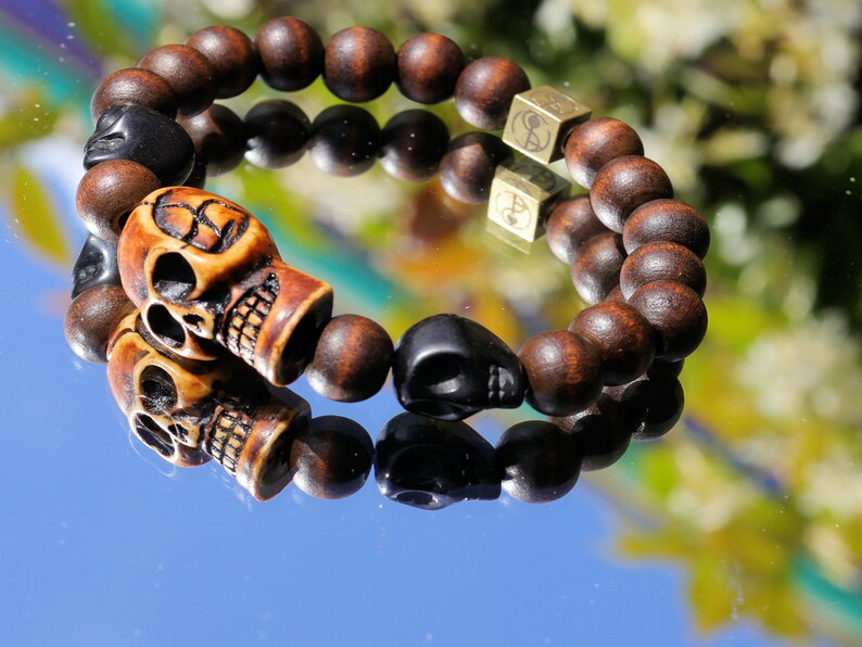 Odd wooden bracelet with Polyresin Mens Skull Bead. Unique and shows the vital Buddhist symbol of emptiness the quality of the universe.