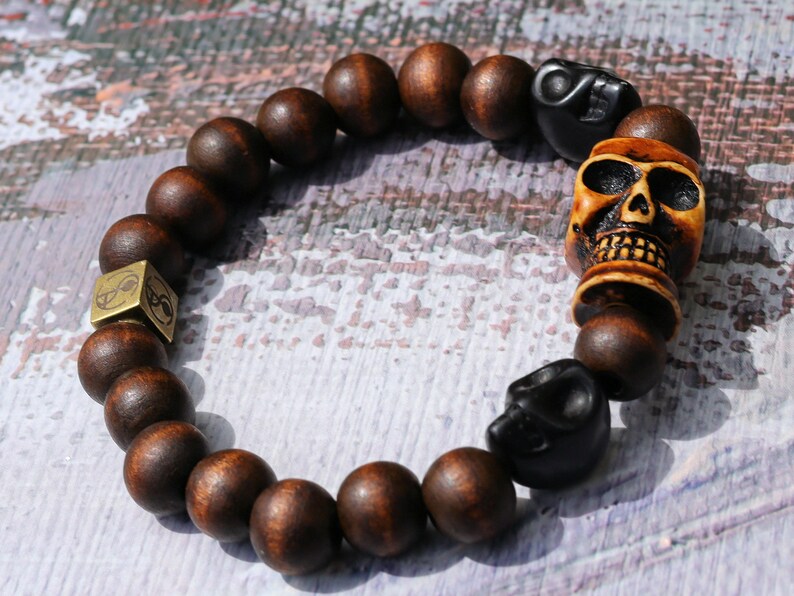 Odd wooden bracelet with Polyresin Mens Skull Bead. Unique and shows the vital Buddhist symbol of emptiness the quality of the universe.