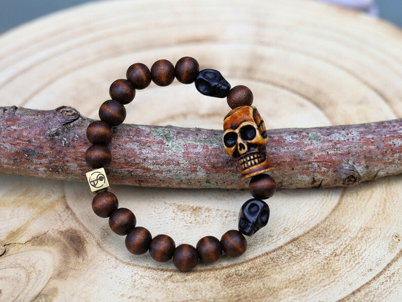 Odd wooden bracelet with Polyresin Mens Skull Bead. Unique and shows the vital Buddhist symbol of emptiness the quality of the universe.
