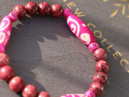 Rhodonite Beads bracelet with Fuschia Tumbling Dice. Bone gemstone jewelry. Haḍīāṁ Jewel winter Collection