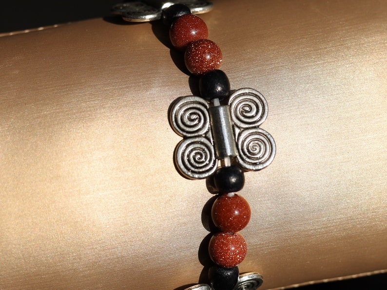 Glittering  Goldstone bracelet combined with wood and Butterfly spacers. A powerful beacon of growth and new beginnings