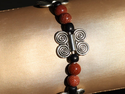 Glittering  Goldstone bracelet combined with wood and Butterfly spacers. A powerful beacon of growth and new beginnings