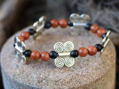 Glittering  Goldstone bracelet combined with wood and Butterfly spacers. A powerful beacon of growth and new beginnings