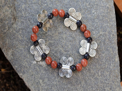 Glittering  Goldstone bracelet combined with wood and Butterfly spacers. A powerful beacon of growth and new beginnings