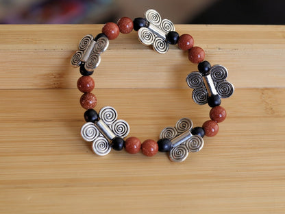 Glittering  Goldstone bracelet combined with wood and Butterfly spacers. A powerful beacon of growth and new beginnings