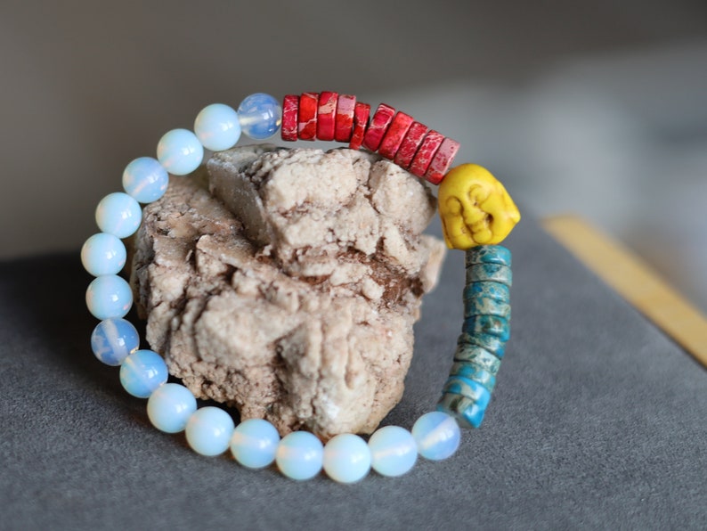 Interesting combination of rounded  Opalite and Heishi beads gives to the bracelet an original and unique design. 1x Howlite bead Buddha