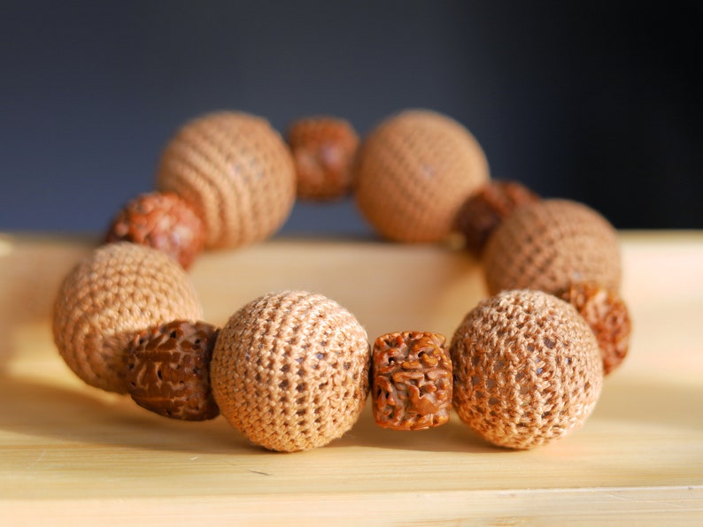 Particularly large Walnut Hand carved Bracelet with Crochet bead light brown. A larger, crocheted bead in light brown.