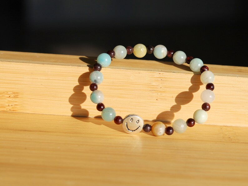 The Bāla Sagrahi Kids Collection. Children's Size Amazonite 6 mm Gemstone Bracelet with 4mm Red Garnet and Flat Round Happy Face Bead.