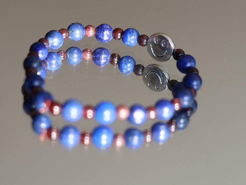 The Bāla Sagrahi Kids Collection. Children's Size Lapis Lazuli 6 mm Gemstone Bracelet with 4mm Red Garnet beads and Happy Face Bead.