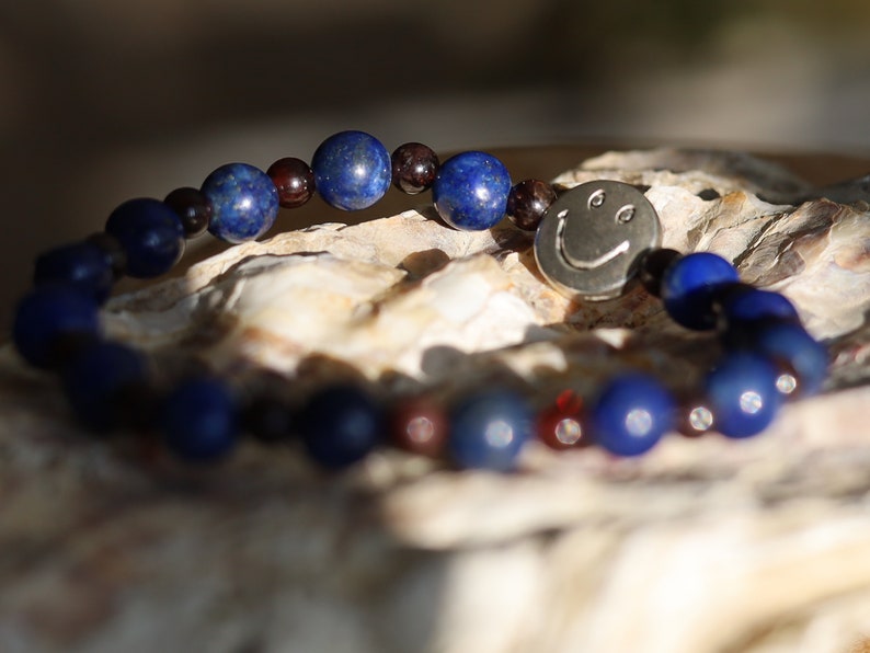 The Bāla Sagrahi Kids Collection. Children's Size Lapis Lazuli 6 mm Gemstone Bracelet with 4mm Red Garnet beads and Happy Face Bead.