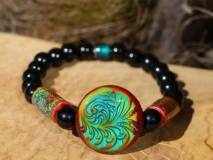 Color-changing Mirāja collection. Black Agates Carnelian bracelet with Mirage Mood Fountain Fern Coin Bead. Mirage Mood Glow Nouveau Bead.
