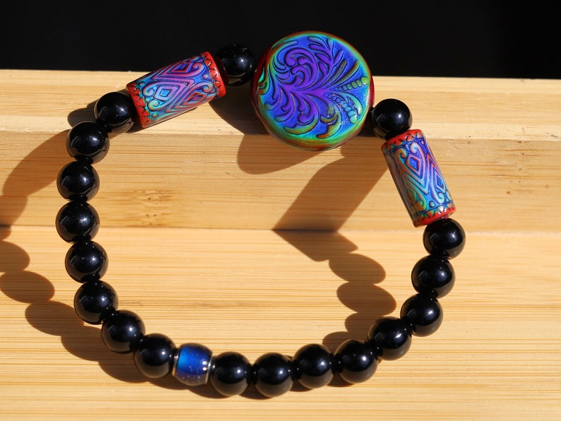 Color-changing Mirāja collection. Black Agates Carnelian bracelet with Mirage Mood Fountain Fern Coin Bead. Mirage Mood Glow Nouveau Bead.