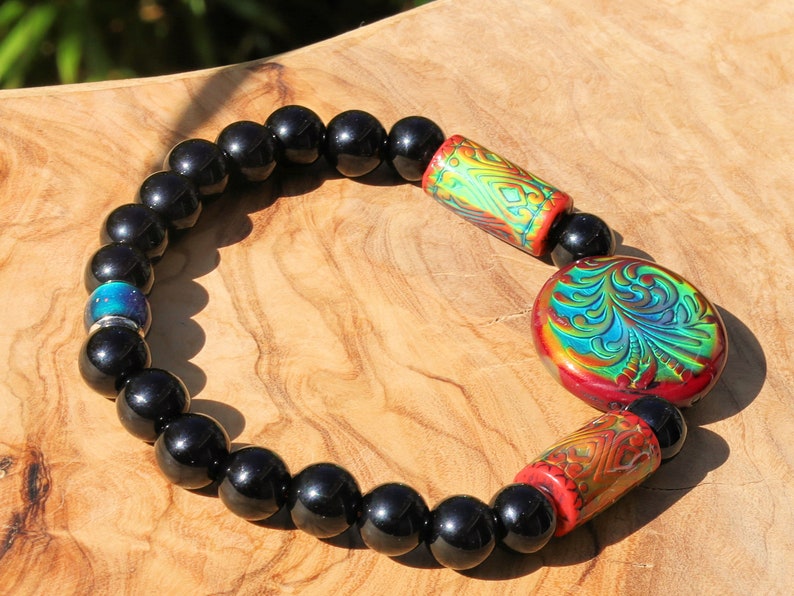Color-changing Mirāja collection. Black Agates Carnelian bracelet with Mirage Mood Fountain Fern Coin Bead. Mirage Mood Glow Nouveau Bead.
