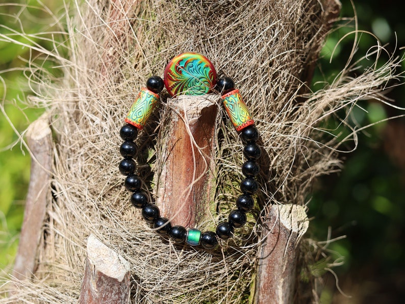 Color-changing Mirāja collection. Black Agates Carnelian bracelet with Mirage Mood Fountain Fern Coin Bead. Mirage Mood Glow Nouveau Bead.