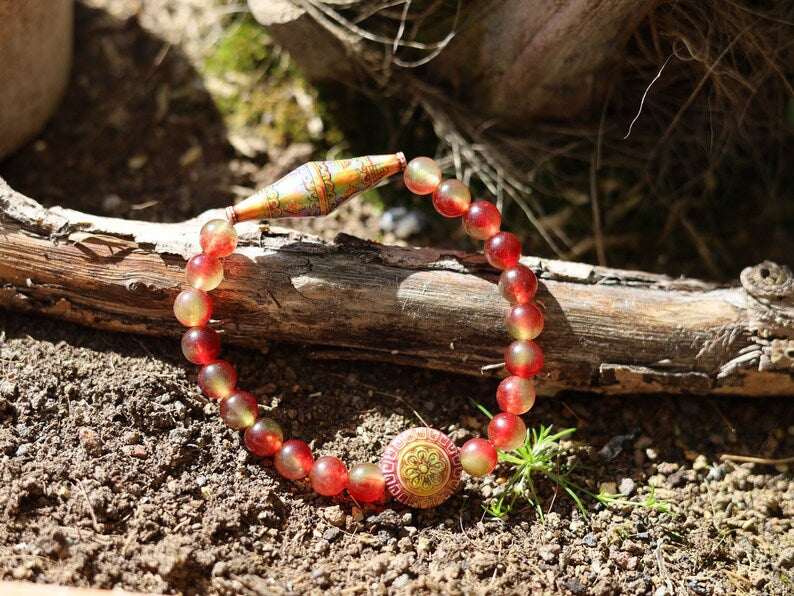Color-changing Mirāja collection.  Watermelon Jade bracelet with Mirage Mood Bali Sunset Elongated Bicone Bead. Mirage Mood Sun Blossom Bead