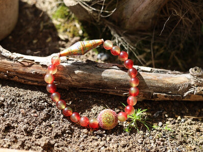 Color-changing Mirāja collection.  Watermelon Jade bracelet with Mirage Mood Bali Sunset Elongated Bicone Bead. Mirage Mood Sun Blossom Bead