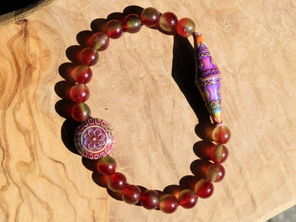 Color-changing Mirāja collection.  Watermelon Jade bracelet with Mirage Mood Bali Sunset Elongated Bicone Bead. Mirage Mood Sun Blossom Bead