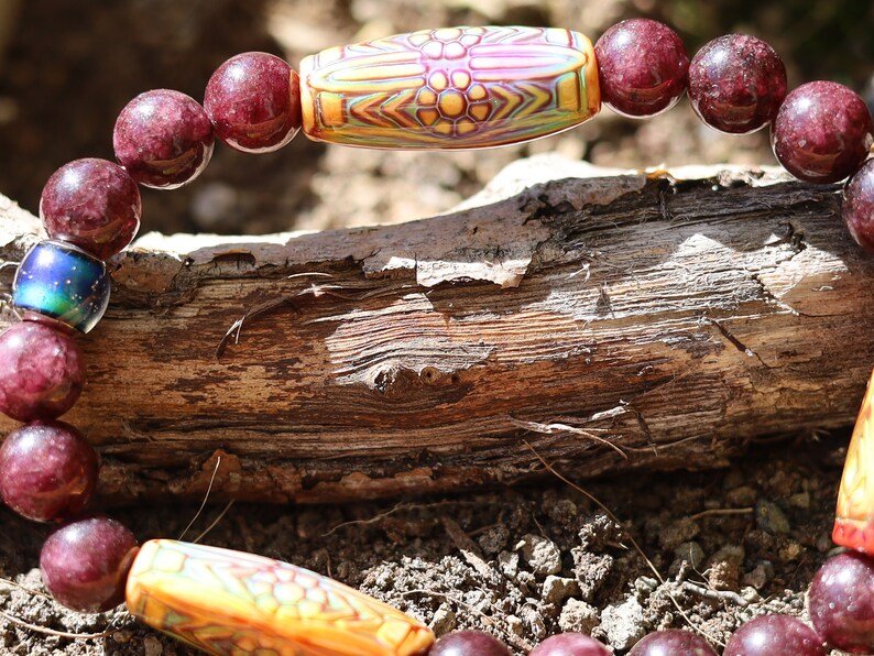 Color-changing Mirāja collection. Dark Red Garnet Jade Beads with Mirage Mood Daisy Ray. making it a popular choice for spiritual practices