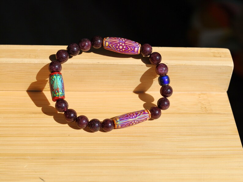 Color-changing Mirāja collection. Dark Red Garnet Jade Beads with Mirage Mood Daisy Ray. making it a popular choice for spiritual practices