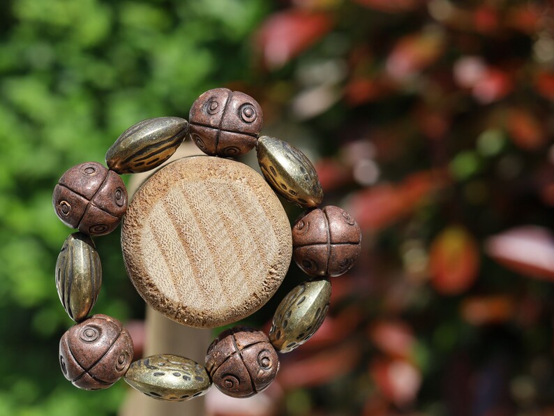 Metallook bead bronze almond shape beads with Metallook bead bronze round with dots.  a powerful way to express your individuality
