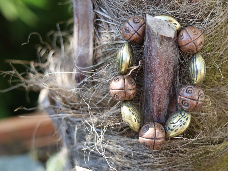 Metallook bead bronze almond shape beads with Metallook bead bronze round with dots.  a powerful way to express your individuality