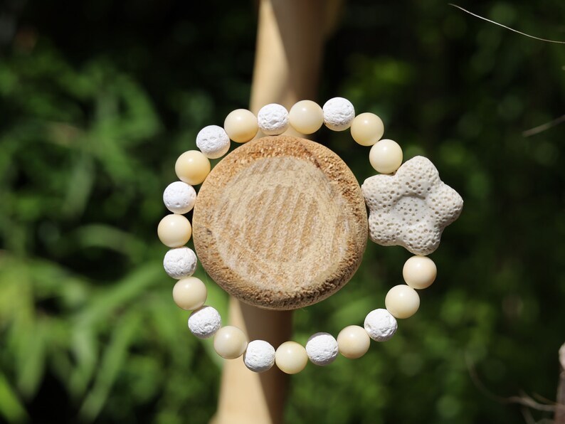 Acai broken white seed beaded bracelet with white lava and Off White/Sand color Flower shaped  bead. Enjoying Aromatherapy