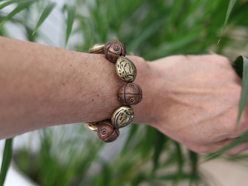 Metallook bead bronze almond shape beads with Metallook bead bronze round with dots.  a powerful way to express your individuality