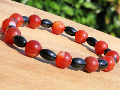 Carnelian red beaded bracelet with  Black Agate Barrel Beads. Agate enhances creativity and strengthens the intellect