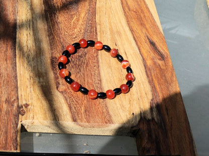 Carnelian red beaded bracelet with  Black Agate Barrel Beads. Agate enhances creativity and strengthens the intellect