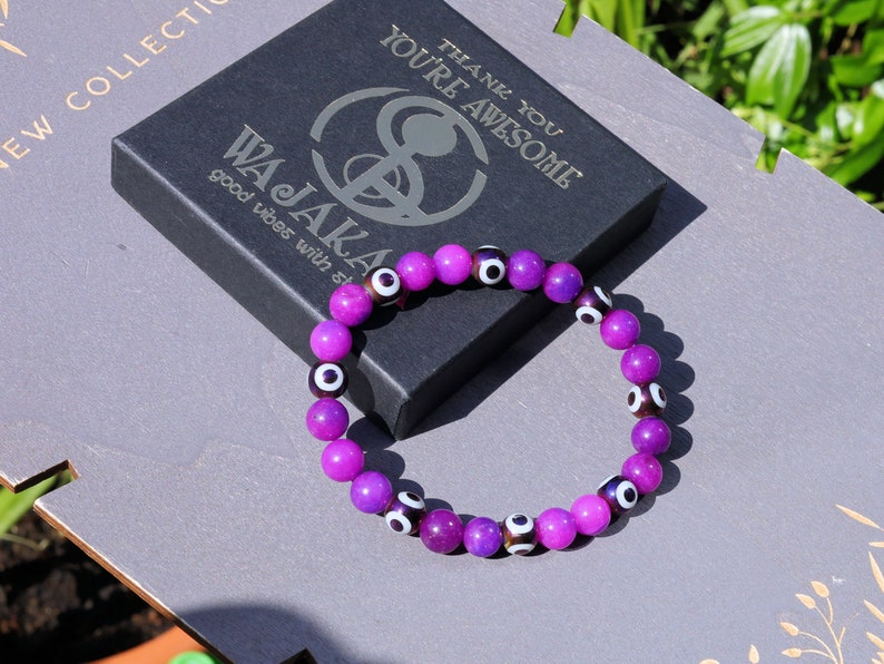 Round with Evil Eye Pattern bracelet with unique Sugilite beads. The central eye design is believed to absorb negative energy