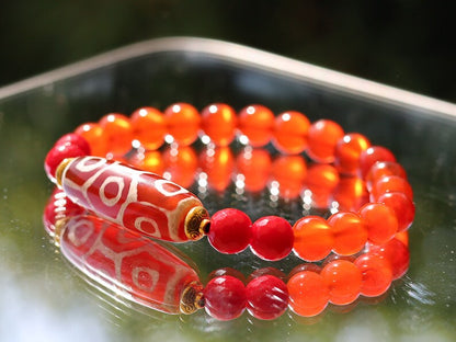 This precious Nine Eyed DZI bead is strung with natural red Carnelian. And Faceted Red Coral beads..