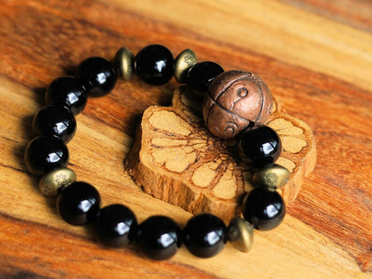 Metallook bead bronze round with dots with black agate beads. is believed to have protective and grounding properties