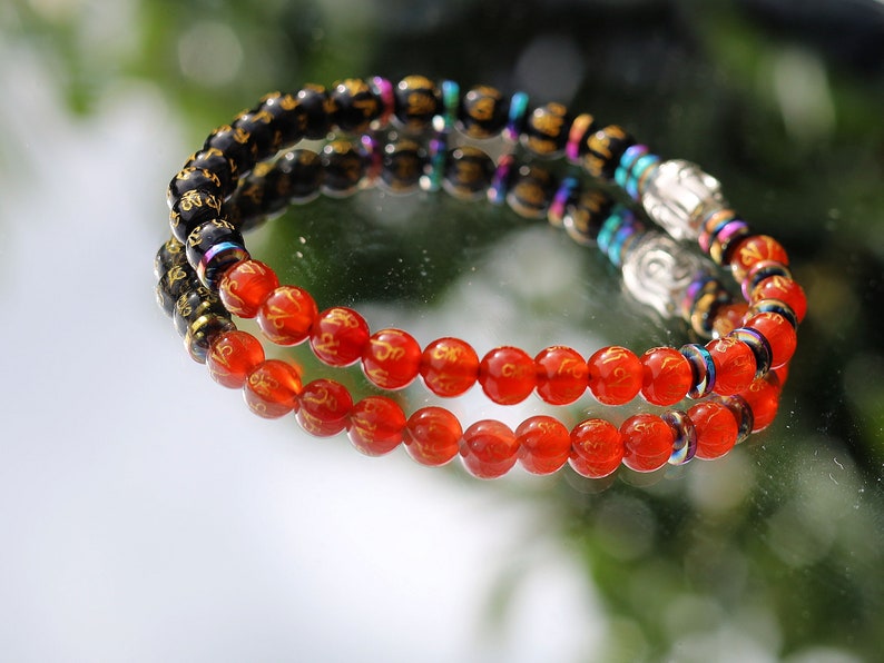 Elevate your spiritual journey and personal style with our stunning Natural Obsidian Beaded Bracelet, graced with a beautifully carved round "Om Mani Padme Hum" design.