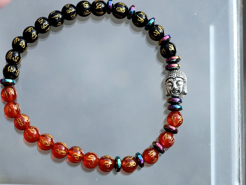 Elevate your spiritual journey and personal style with our stunning Natural Obsidian Beaded Bracelet, graced with a beautifully carved round "Om Mani Padme Hum" design.