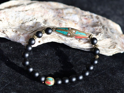 The Shaligram stones with Nepalese Brass beads from Nepal. Inlaid with turquoise and coral. Size : 25 x 10 mm