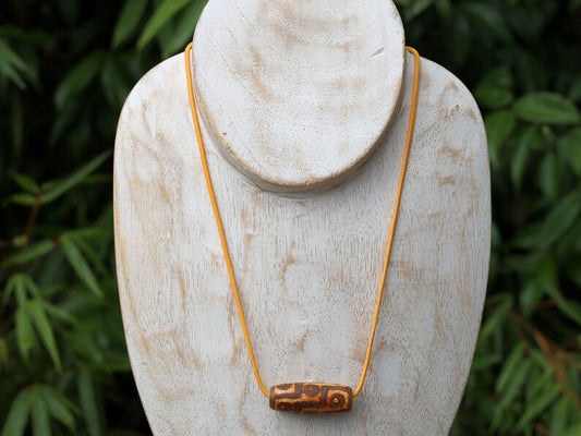 9 Eyes Dzi Bead made of brown grained relief Agate necklace.  It's believed to offer protection, promote spiritual growth, and bring harmony