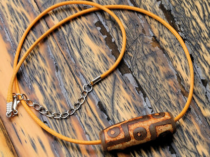 9 Eyes Dzi Bead made of brown grained relief Agate necklace.  It's believed to offer protection, promote spiritual growth, and bring harmony